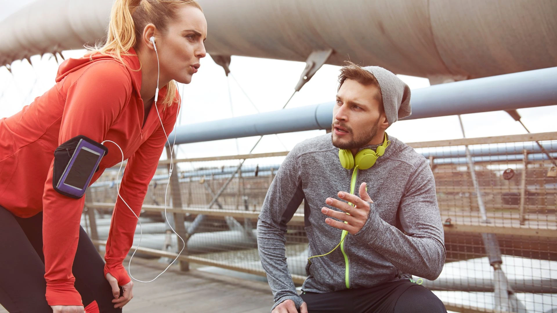 Two athletes discussing how to improve running cadence during a break.