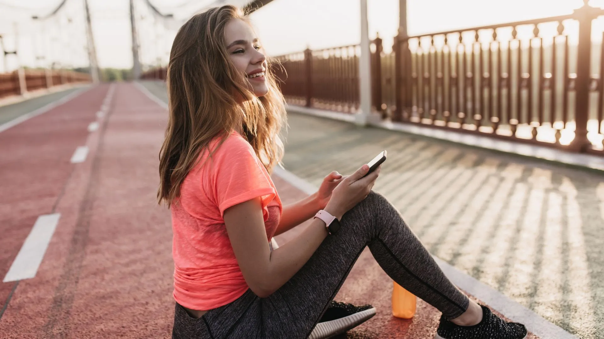 A happy runner checking their workout summary on the best running application.