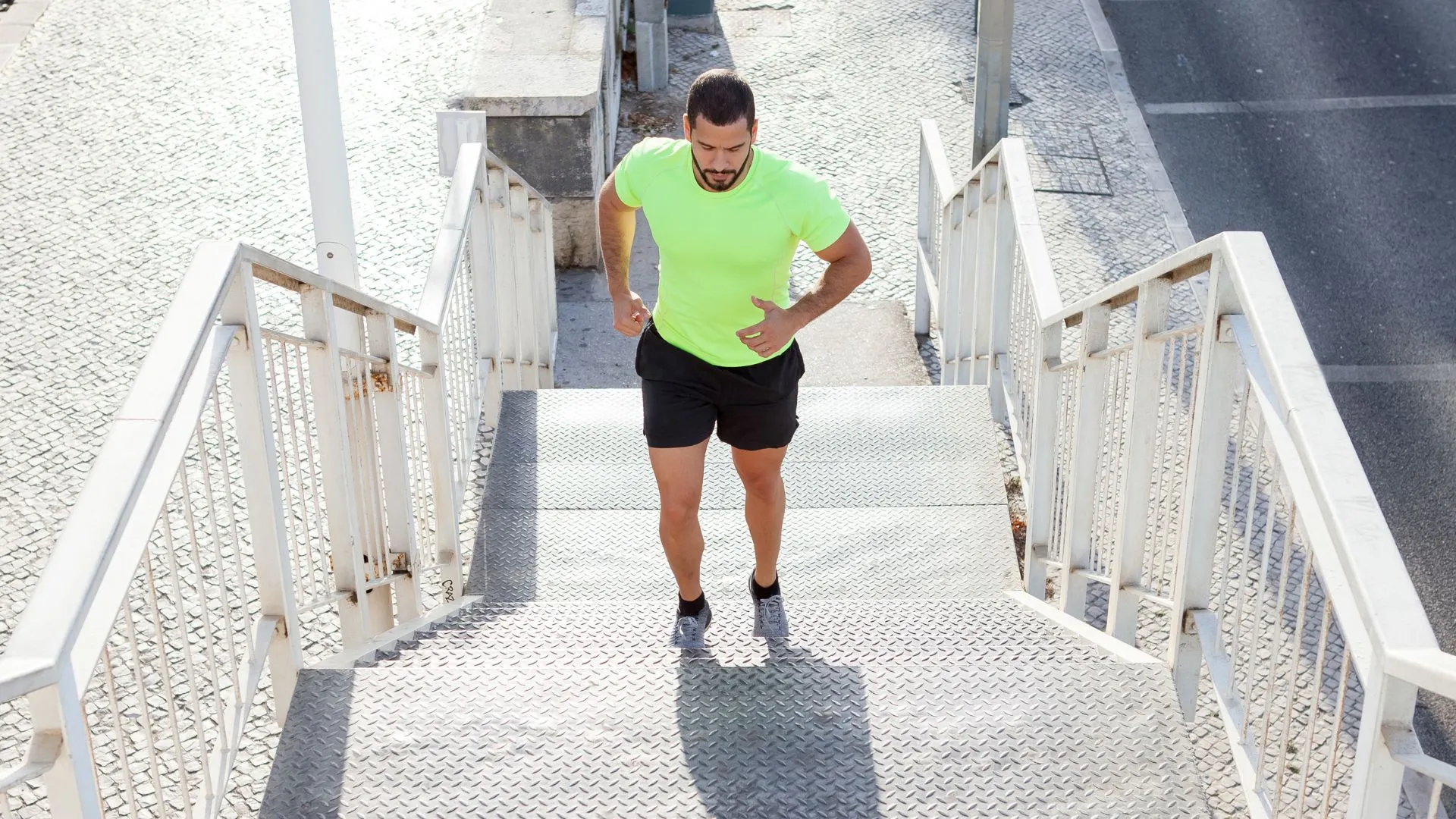 Corredor sobe escadas para aquecer antes de correr.