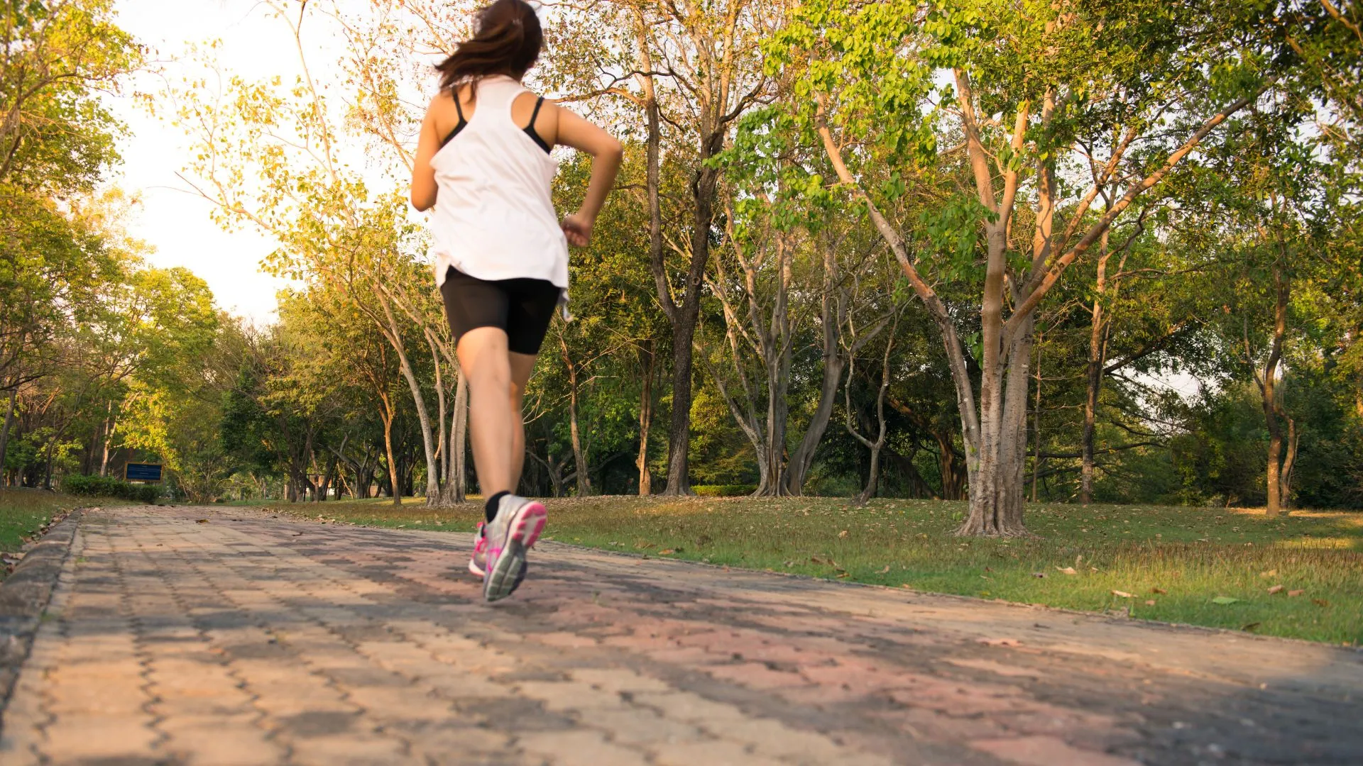 An athlete runs with a steady, natural cadence outdoors.